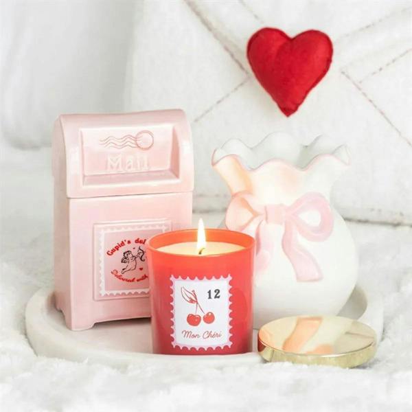 Cherry Blossom scented candle red jar with gold lid beside heart decor and pink box