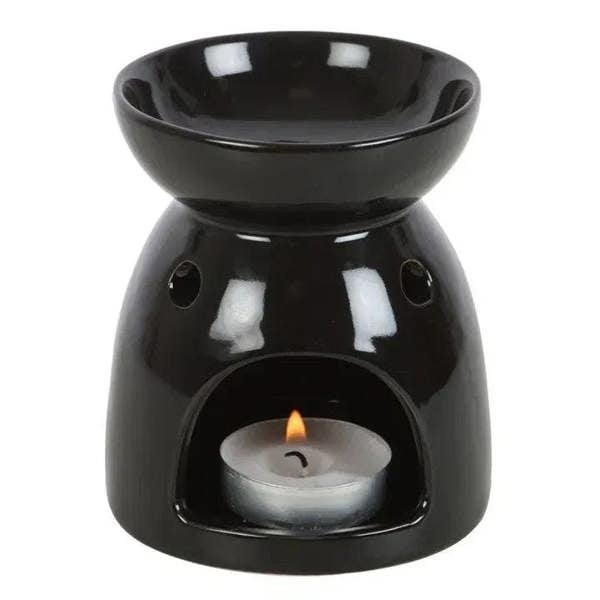 Black oil burner with candle flame in center bowl and two side cutouts