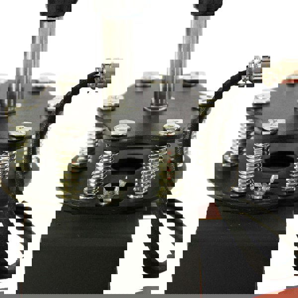 Close-up of the PixMax Sublimation Cap Heat Press Machine's adjustable pressure plate with metal springs and a sturdy base