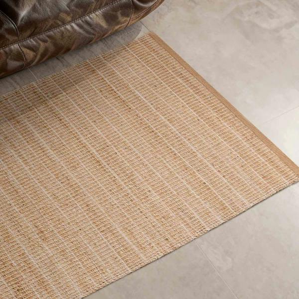 Textured beige rug on a tiled floor with a brown leather chair corner.