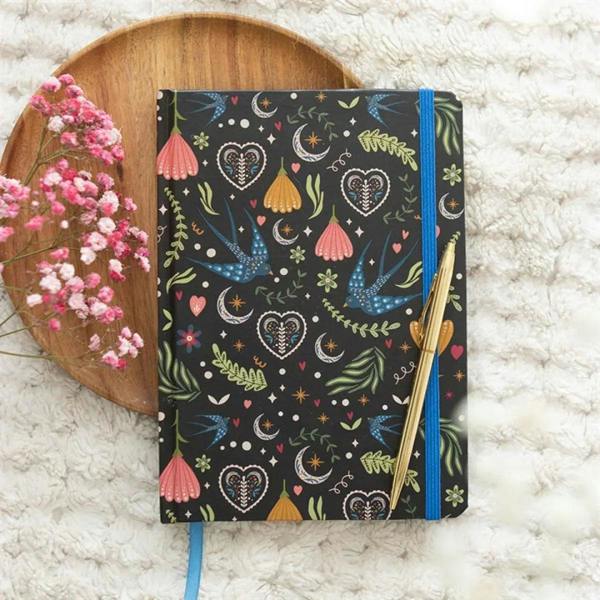Midnight dark notebook with colorful heart-and-bird print, blue elastic strap, pen included