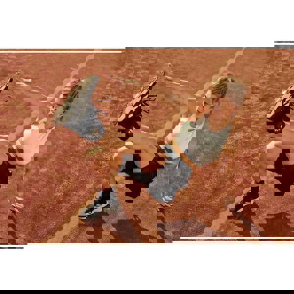 Woman exercising on a running track wearing Adidas 1kg ankle/wrist weights