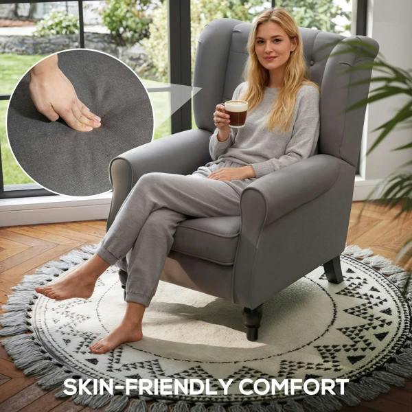 Dark grey wingback armchair with button-tufted back, turned legs, and plush seat