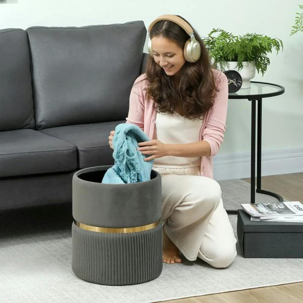 Grey ribbed storage ottoman with open top as a person places a folded blanket inside