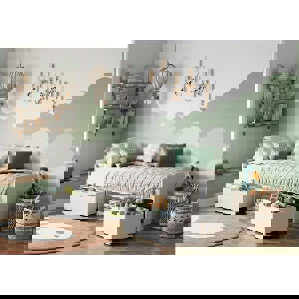 Children's bedroom with a bed, shelves, and toys against a cloud-themed wall.