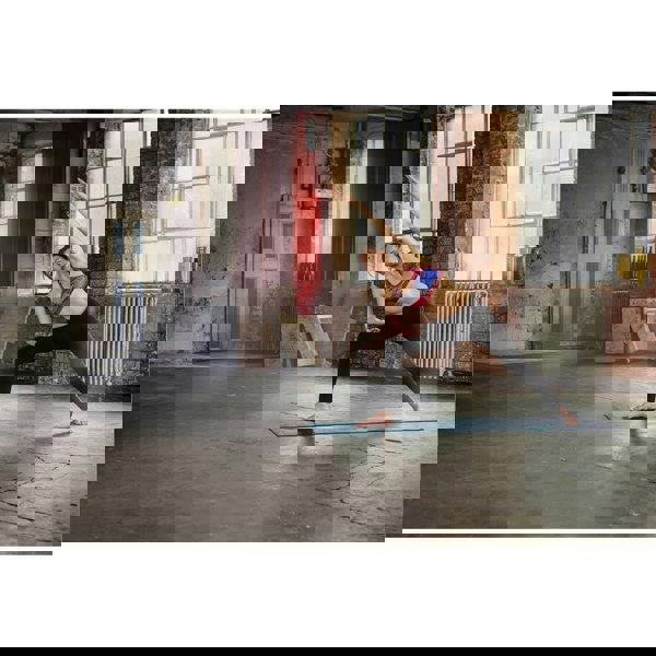 Reebok Double Sided 4mm Yoga Mat - Green Stripes - Woman performing a stretching workout