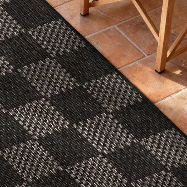 Black and gray patterned rug on a tiled floor