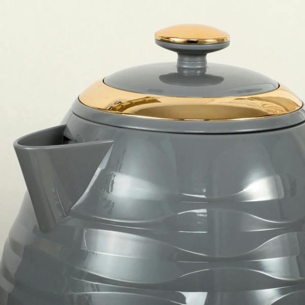 Grey kettle with gold-colored lid and spout area, close-up