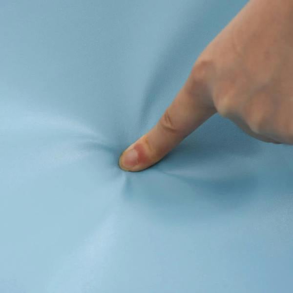 Close-up of smooth light blue PU foam cover being pressed by a hand