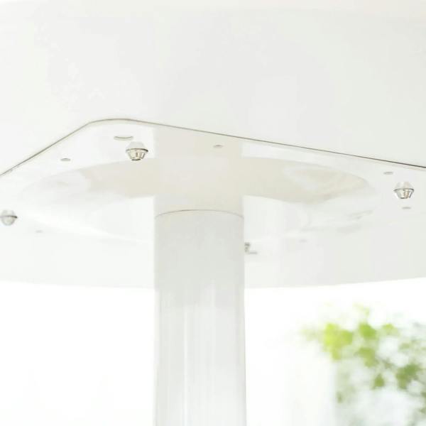 Underside view of a white round pedestal dining table top and central support column