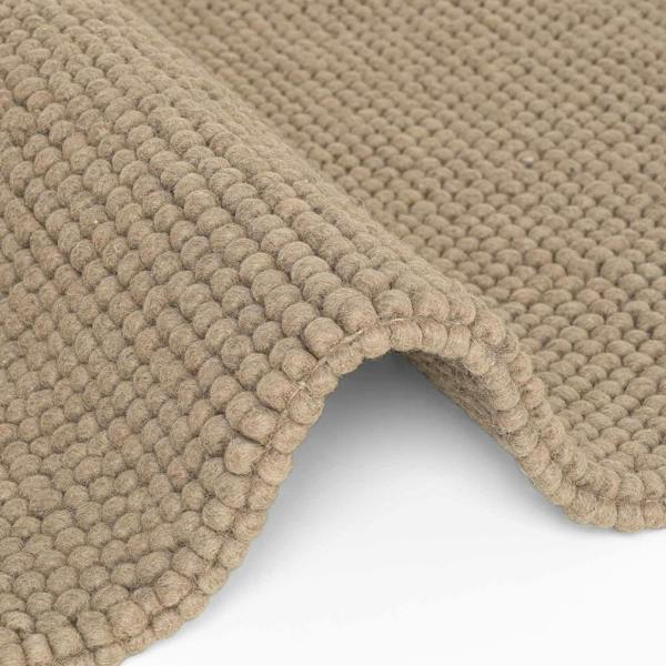 Close-up of a beige textured rug on a white background