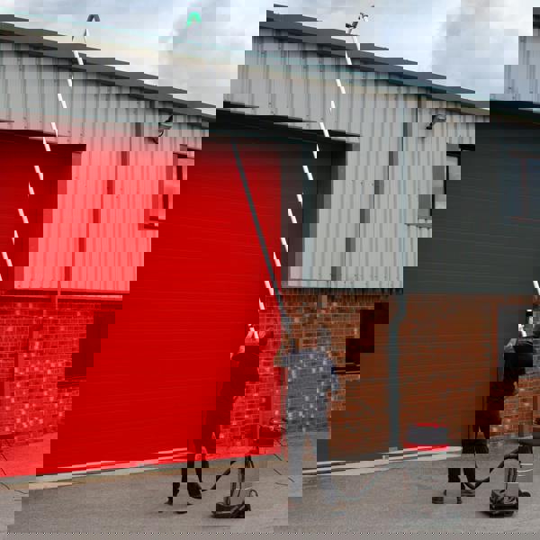 80L wet and dry vacuum with gutter vacuum poles, user extending pole towards a red garage door, showcasing versatility and reach