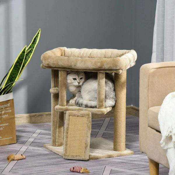 Brown cat tree tower with top perch and enclosed cubby; cat sits inside near jute scratch pad