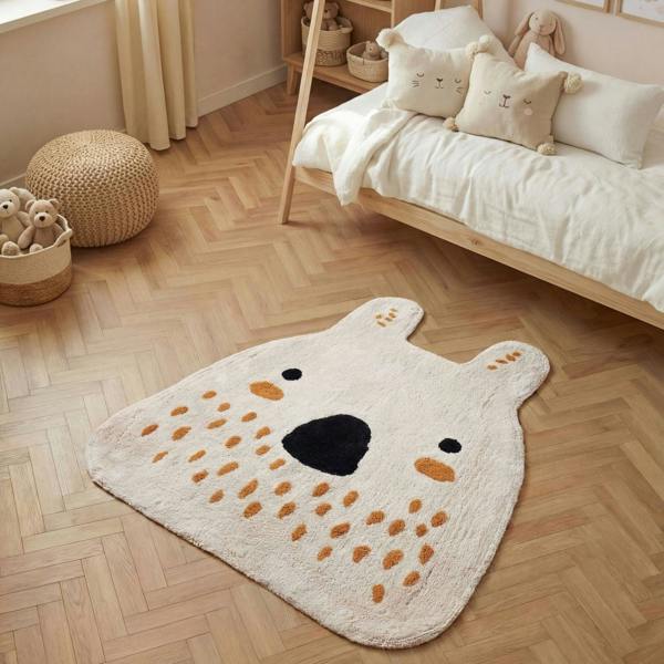 Children's room with a bear-shaped rug on a wooden floor