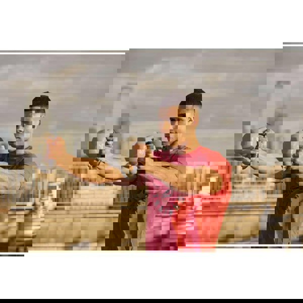 Man performing a kettlebell workout outside using 2 Reebok 6kg Cast Iron Kettlebells