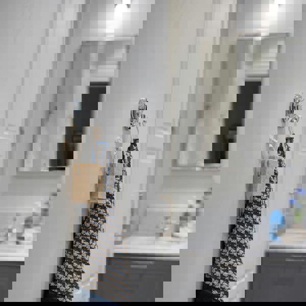 Polished chrome double towel hook on bathroom wall