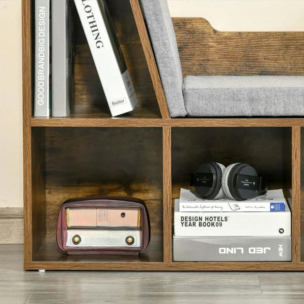 Close-up of rustic brown cubby shelves with books, gray cushion, and small decor items