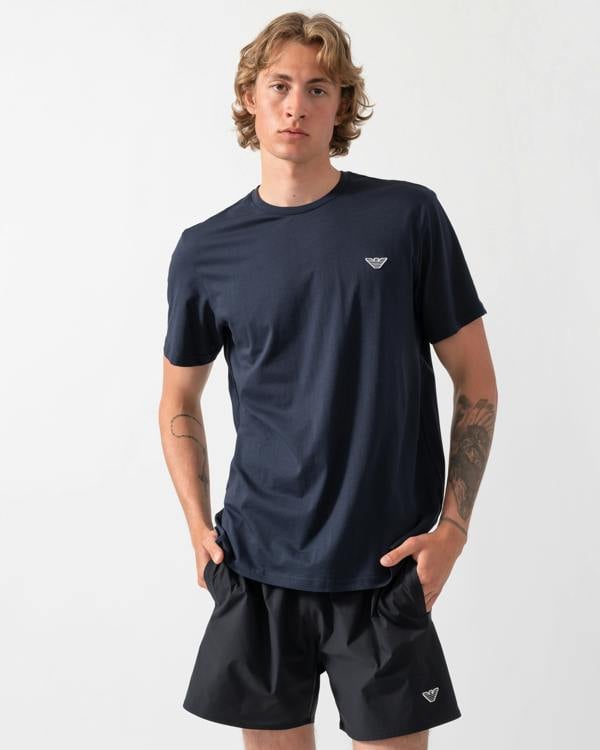 model wearing an Emporio Armani Mens Beach T-Shirt with Eagle Logo in Armani Blue