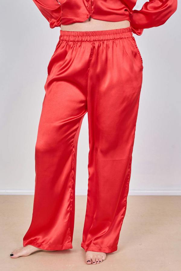 Red satin outfit with a top and pants on a plain background
