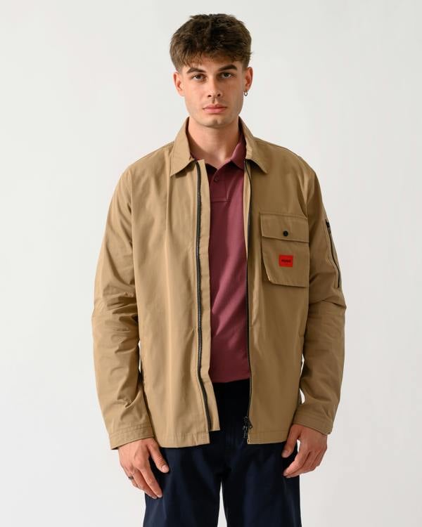 wide shot of a model wearing a HUGO Emmond Mens Zip Overshirt in Beige Overflow 928