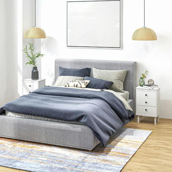 White three-drawer bedside cabinet with round black knobs, topped for bedside essentials.