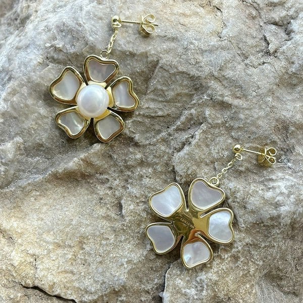 Freshwater pearl and mother of pearl gold vermeil earrings on a rock.