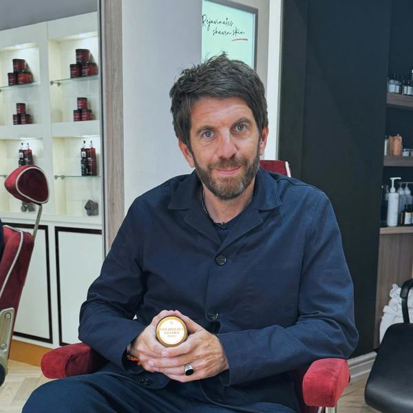 Andy Goldstein holding a pot of Goldstein's Golden Paste