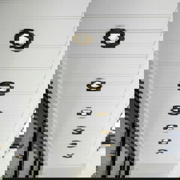 black outside downlight mounted along the soffit of a modern home