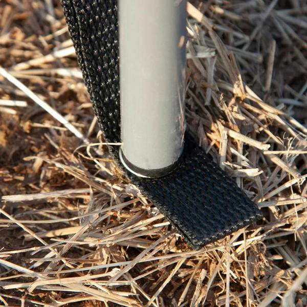 Windbreak pole sleeve and base shown on sandy ground, with black fabric trim