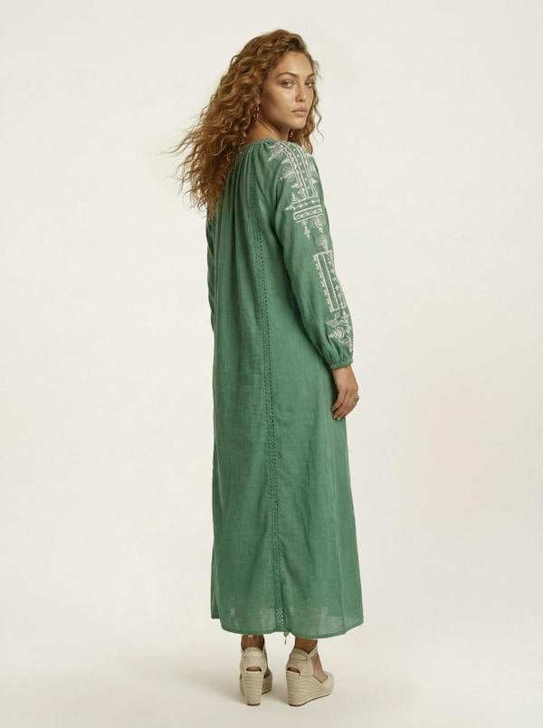 Woman wearing a green dress with text pattern on a white background