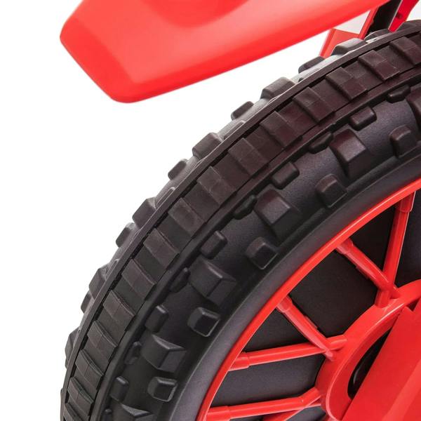 Close-up of black tire tread and red wheel spokes on kids electric motorcycle ride-on