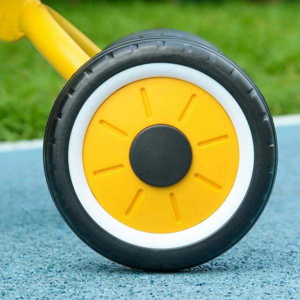 Close-up of yellow wheel hub with white rim on a kids tricycle tire