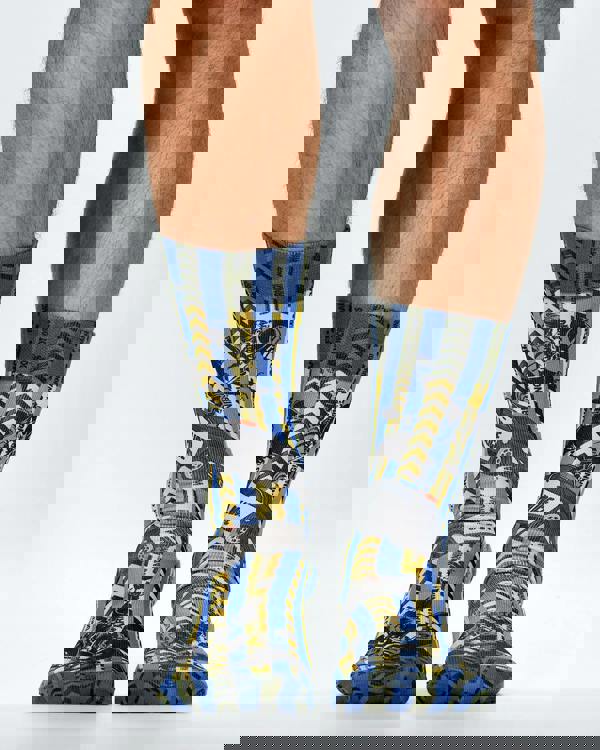 Colorful socks with a police theme socks pattern worn by a person on a light gray background