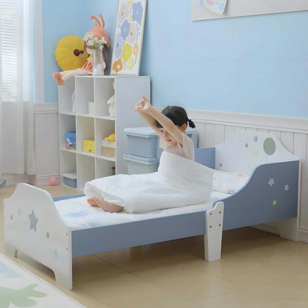 Toddler bed frame with blue guardrails and white panels, styled in a kid bedroom