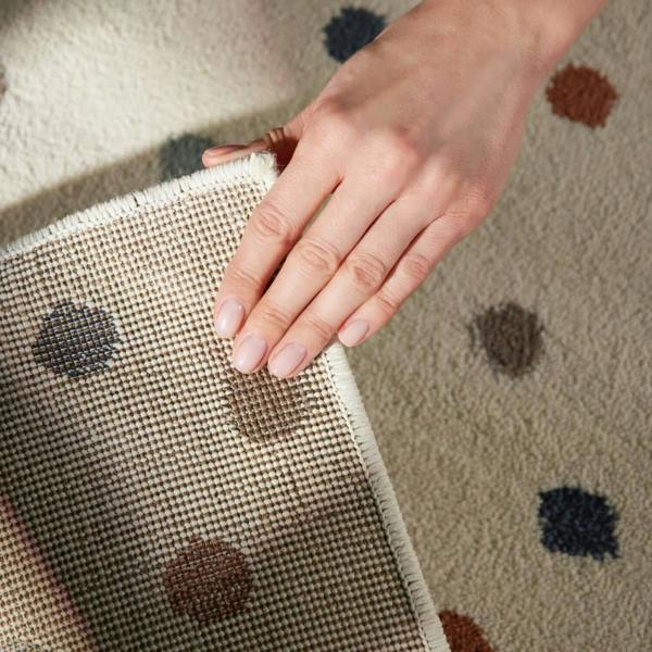 Hand touching a textured fabric surface with a patterned background