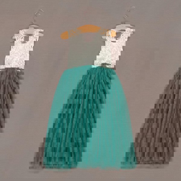 Teal dress with white lace top on a hanger against a brown background