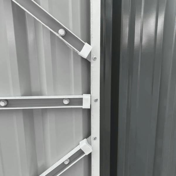 Grey metal shed door latch and internal locking bar on the double-door edge