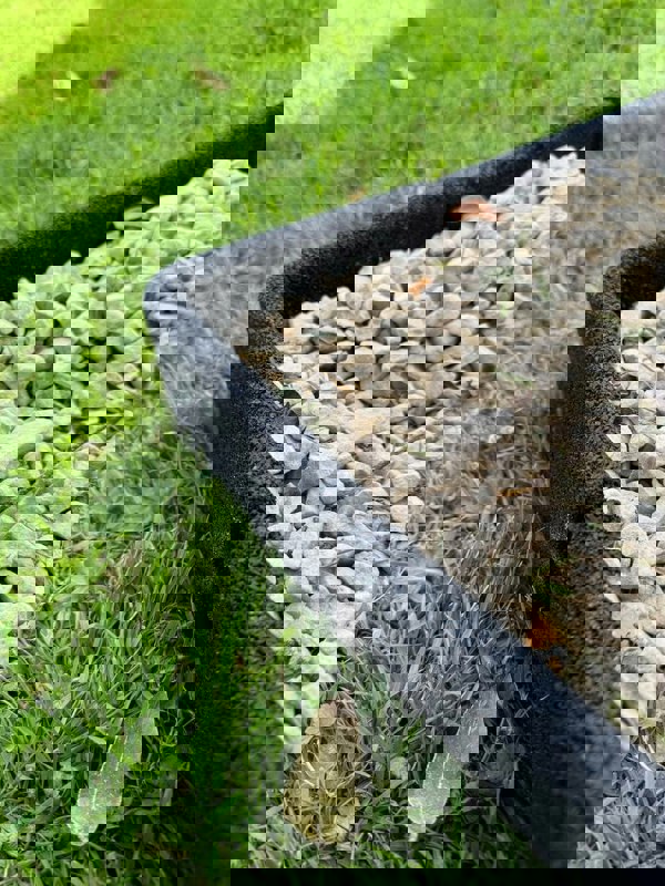 Black Flexiborder in a garden edging the lawn and stones