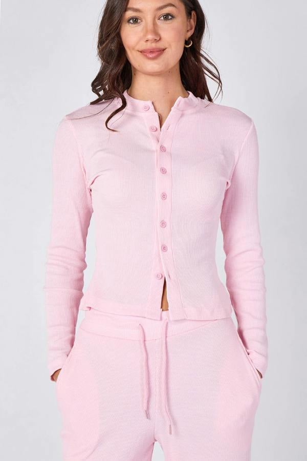 Woman wearing a pink pajama set against a white background