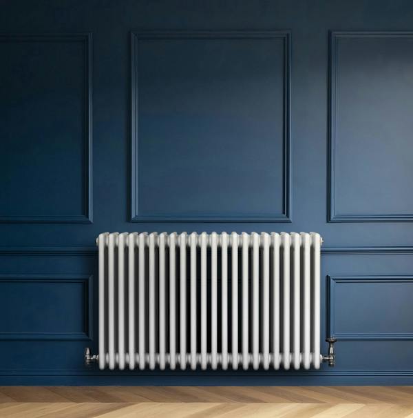 Traditional white 4 column radiator with smooth, glossy finish, mounted against a deep blue wall, enhancing modern decor