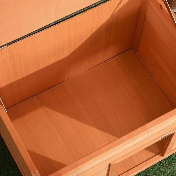 Interior view of yellow wooden dog kennel showing floor boards and open front opening
