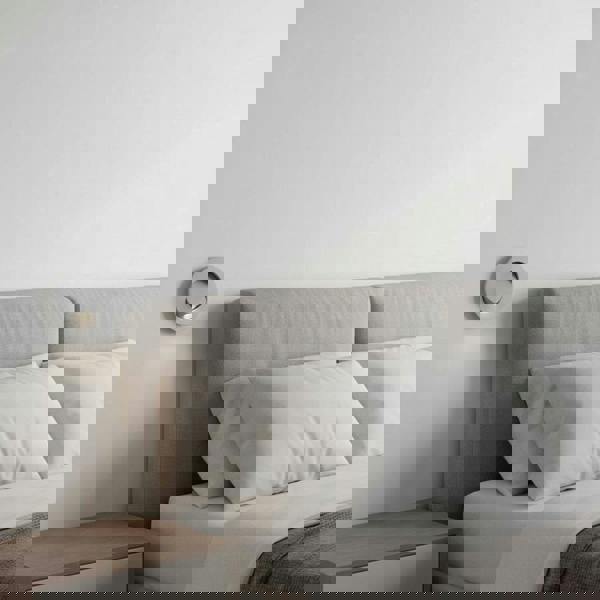 white recessed bedside reading light mounted on the wall next to a bed in a modern clean bedroom