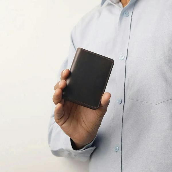 Brown leather Mayfair 2511 cardholder held in hand, showing its compact and premium craftsmanship.