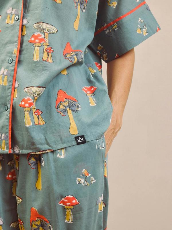 Woman wearing a mushroom patterned oversized pyjama set against a plain background