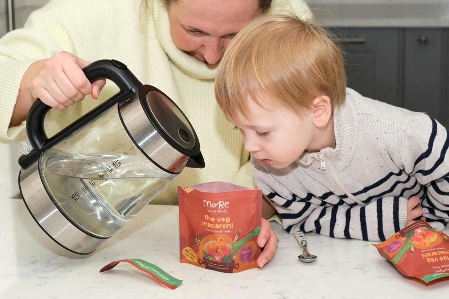 a mum and toddler preparing a more toddler meal by adding hot water