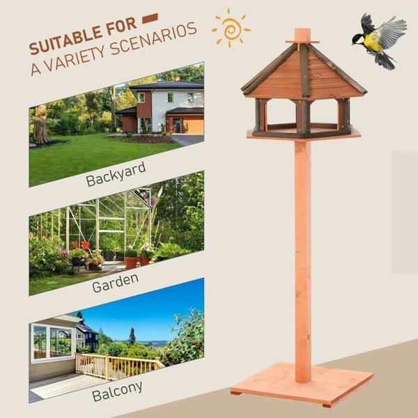 Brown wooden bird feeding table with pitched roof on freestanding post base