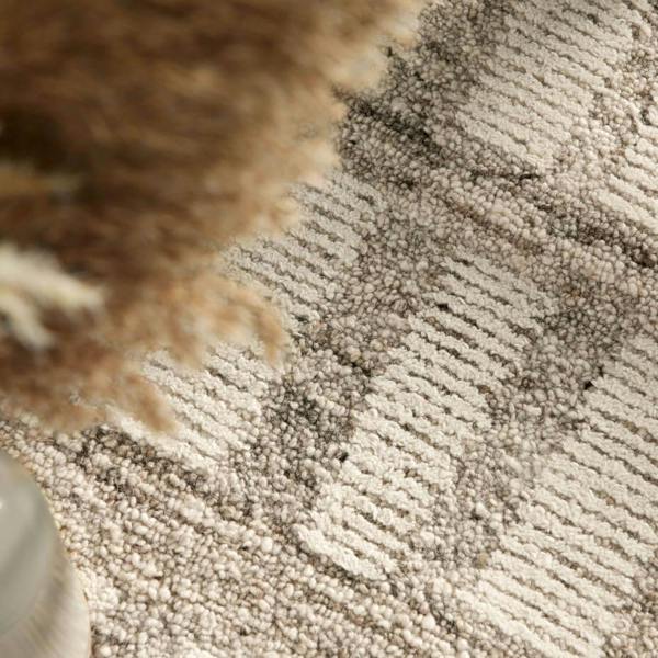Close-up of textured beige carpet with a blurred area
