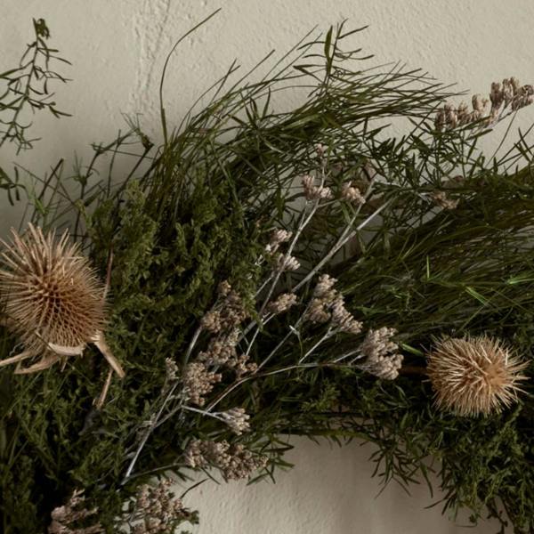 Detailed close-up of the Rowan wreath showing dried thistles, silvery botanicals, and hand-woven panchu sticks.