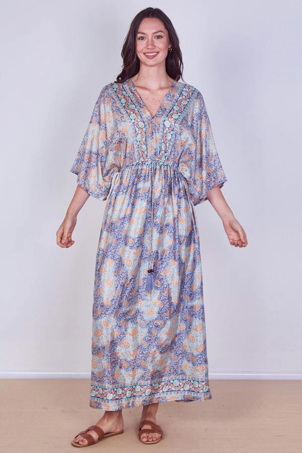 Woman wearing a floral dress against a plain background