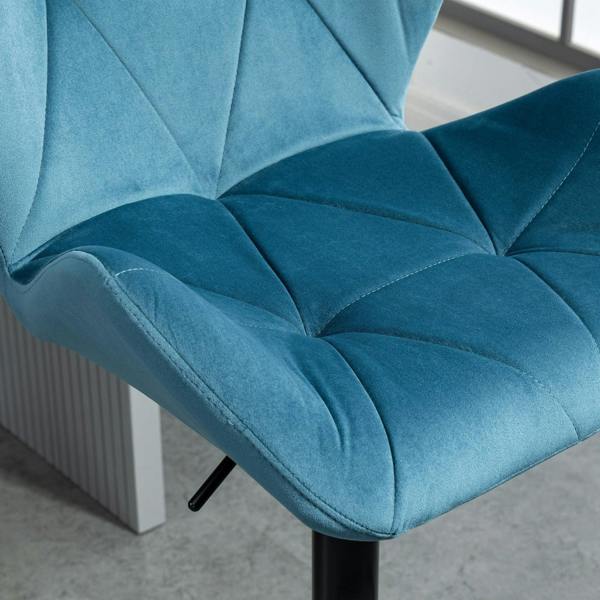Blue velvet bar stool close-up of tufted seat and armrest, black pedestal